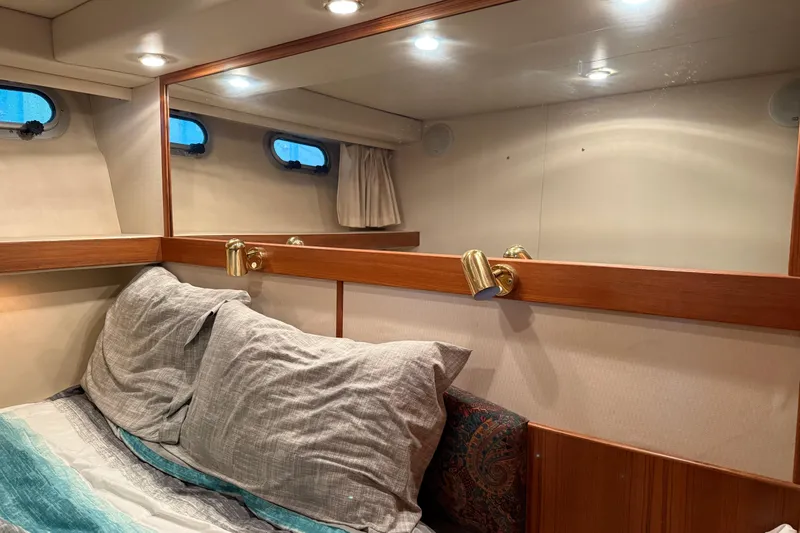 Slide: The Image of Cozy cabin interior of 1997 Bayliner 47 Motoryacht with mirror and bedding. - 20