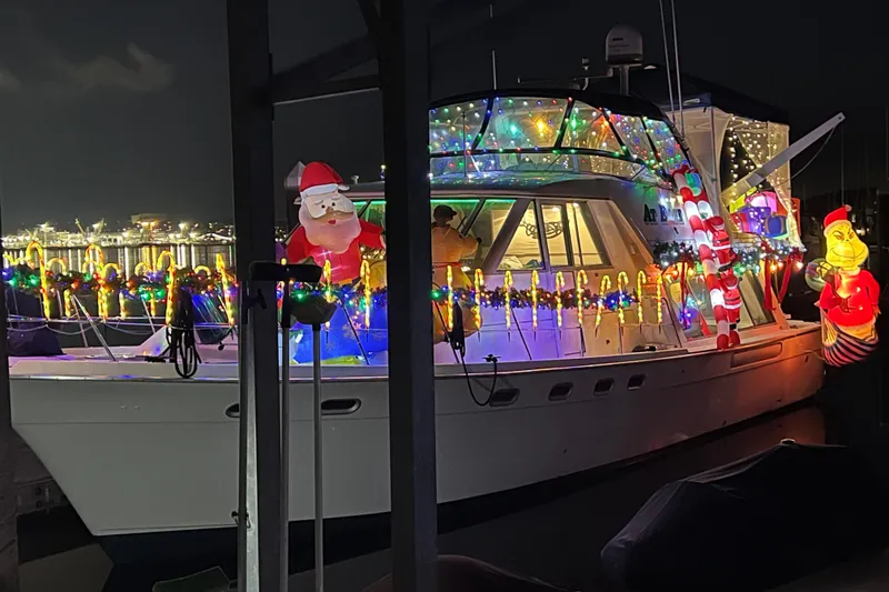 Slide: The Image of 1997 Bayliner 47 Motoryacht decorated with festive Christmas lights and inflatable figures at night. - 31