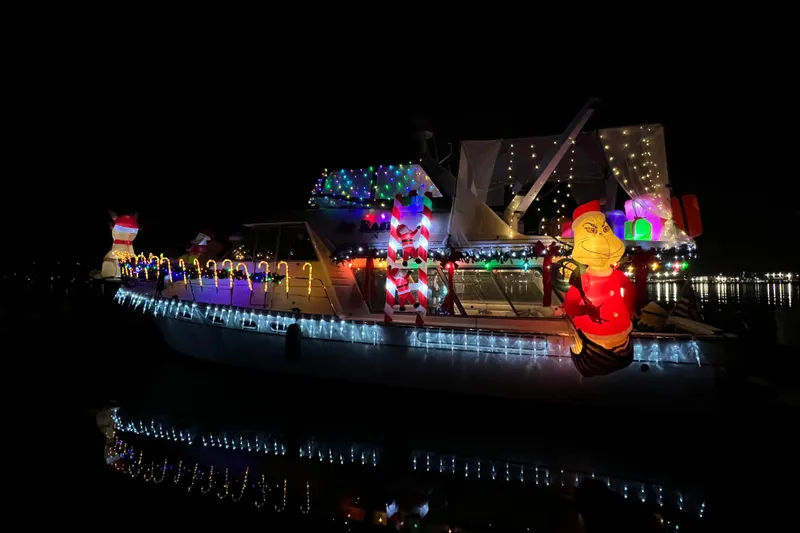 Slide: The Image of 1997 Bayliner 47 Motoryacht adorned with festive Christmas lights and decorations at night. - 32