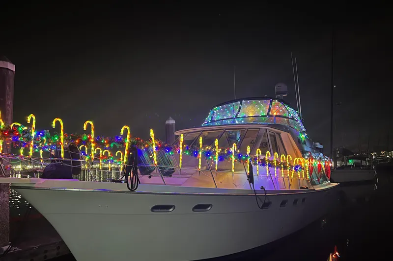 Slide: The Image of 1997 Bayliner 47 Motoryacht adorned with colorful holiday lights at night. - 33