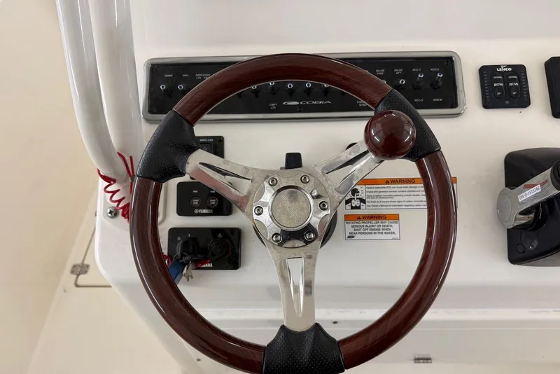 Slide: The Image of Steering wheel of 2016 Cobia 296 Center Console boat with control panel. - 14