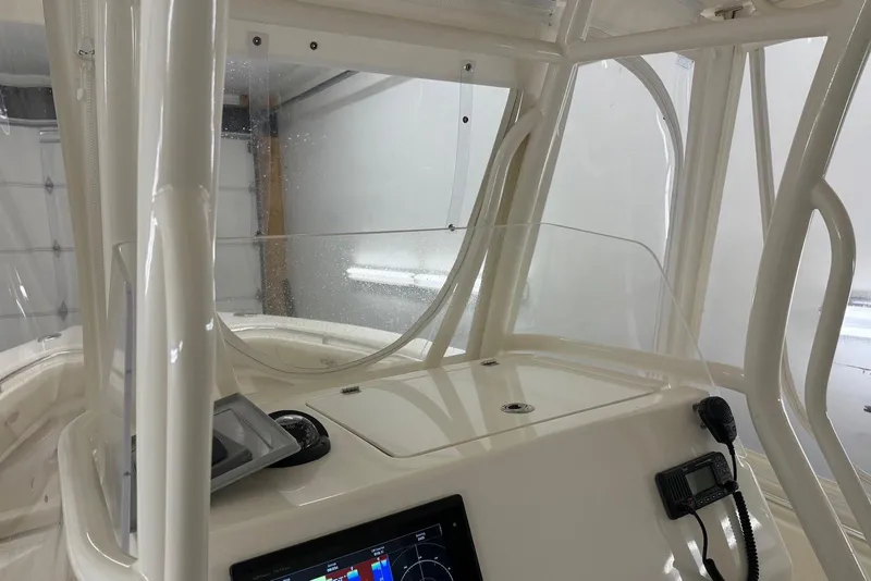 Slide: The Image of 2016 Cobia 296 Center Console boat interior with navigation equipment and clear windshield. - 18
