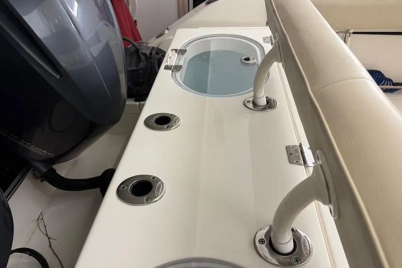 Slide: The Image of 2016 Cobia 296 Center Console boat interior with rod holders and livewell. - 20