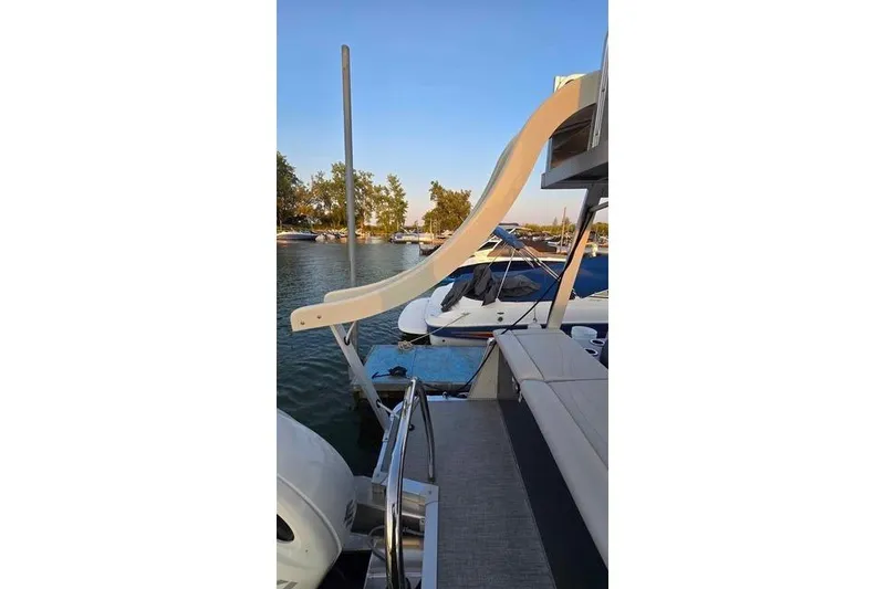 Slide: The Image of 2023 Avalon Catalina Funship 2585 with slide, docked on a serene lake. - 15