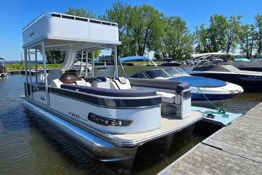 Slide: The Image of 2023 Avalon Catalina Funship 2585 pontoon boat docked on a sunny day. - 2