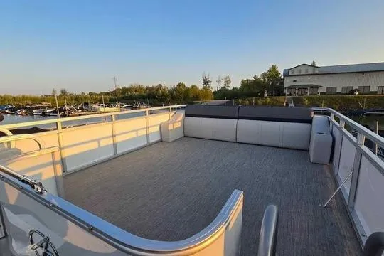 Slide: The Image of 2023 Avalon Catalina Funship 2585 pontoon boat with spacious deck and seating, docked at marina. - 8