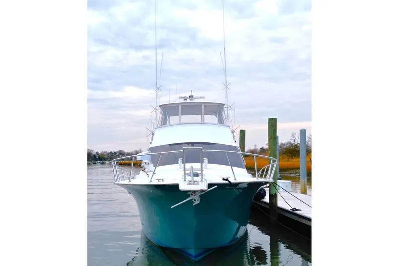 Slide: The Image of 1999 Ocean Yachts 60 Super Sport docked, front view with calm water and cloudy sky. - 4