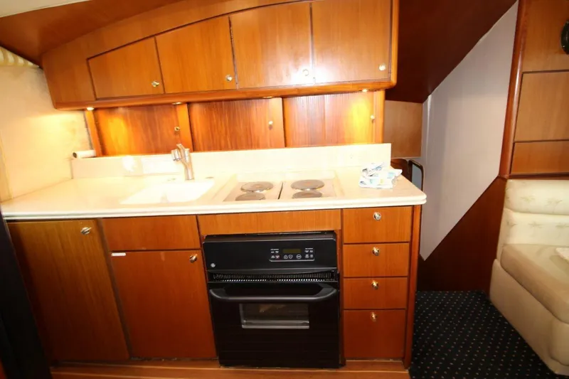 Slide: The Image of 1999 Ocean Yachts 60 Super Sport kitchen with wooden cabinets and compact appliances. - 45