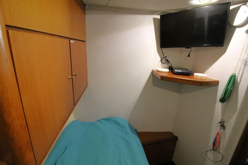 Slide: The Image of Cozy cabin interior of 1999 Ocean Yachts 60 Super Sport with TV and storage. - 54