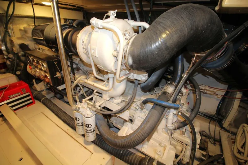 Slide: The Image of Engine room of 1999 Ocean Yachts 60 Super Sport, showcasing mechanical components and hoses. - 62