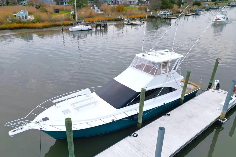 Slide: The Image of 1999 Ocean Yachts 60 Super Sport docked in a serene marina setting. - 8