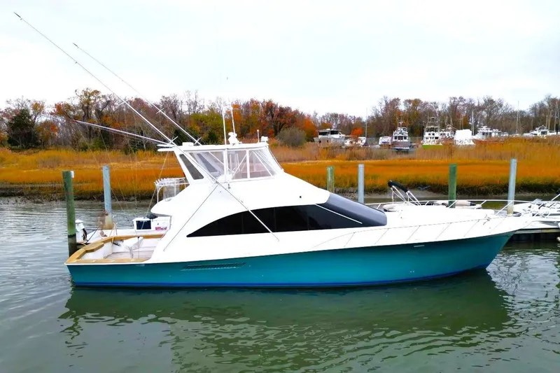 The Image of 1999 Ocean Yachts 60 Super Sport boat docked in a serene marina setting. - 0