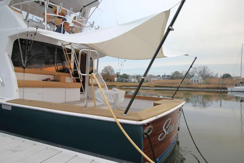 Slide: The Image of 1999 Ocean Yachts 60 Super Sport docked, featuring spacious deck and fishing equipment. - 12