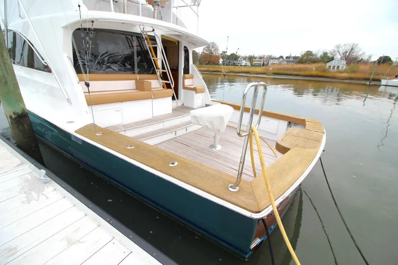 Slide: The Image of 1999 Ocean Yachts 60 Super Sport docked, featuring spacious deck and seating area. - 13