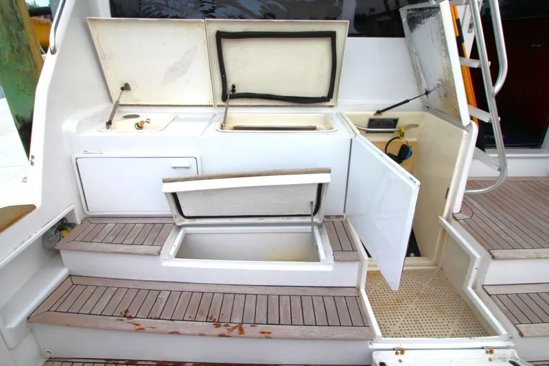 Slide: The Image of 1999 Ocean Yachts 60 Super Sport deck with open storage compartments and steps. - 15