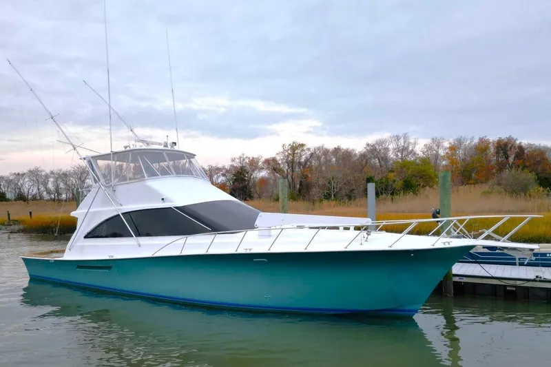 Slide: The Image of 1999 Ocean Yachts 60 Super Sport boat docked in a serene marina setting. - 2