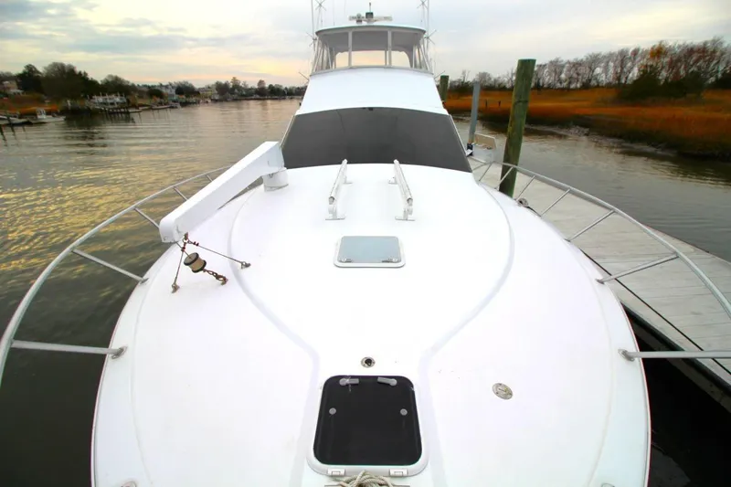 Slide: The Image of 1999 Ocean Yachts 60 Super Sport yacht docked on a calm waterway. - 22