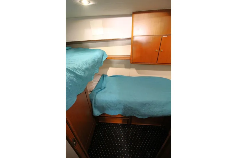 Slide: The Image of Bunk beds with blue covers in 1999 Ocean Yachts 60 Super Sport cabin. - 53