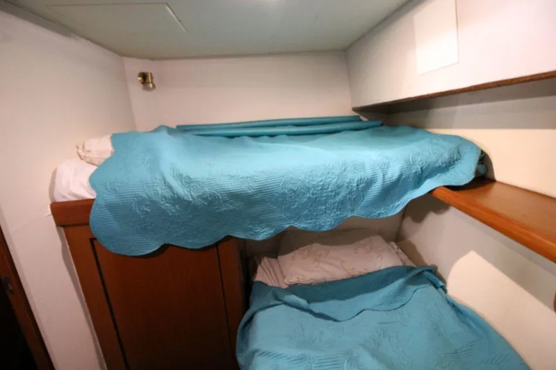 Slide: The Image of Bunk beds with blue covers in 1999 Ocean Yachts 60 Super Sport cabin. - 55