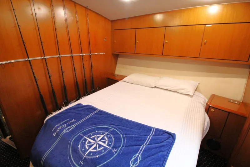 Slide: The Image of 1999 Ocean Yachts 60 Super Sport cabin with fishing rods and cozy bed. - 57