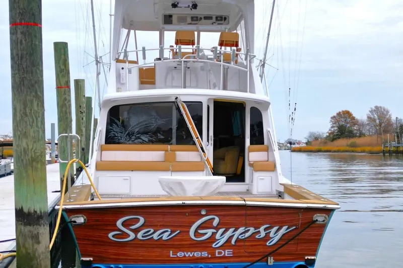Slide: The Image of 1999 Ocean Yachts 60 Super Sport docked, rear view with "Sea Gypsy" name visible. - 6