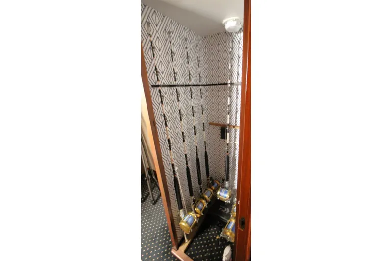 Slide: The Image of Fishing rod storage on 1999 Ocean Yachts 60 Super Sport, featuring patterned walls and carpet. - 60