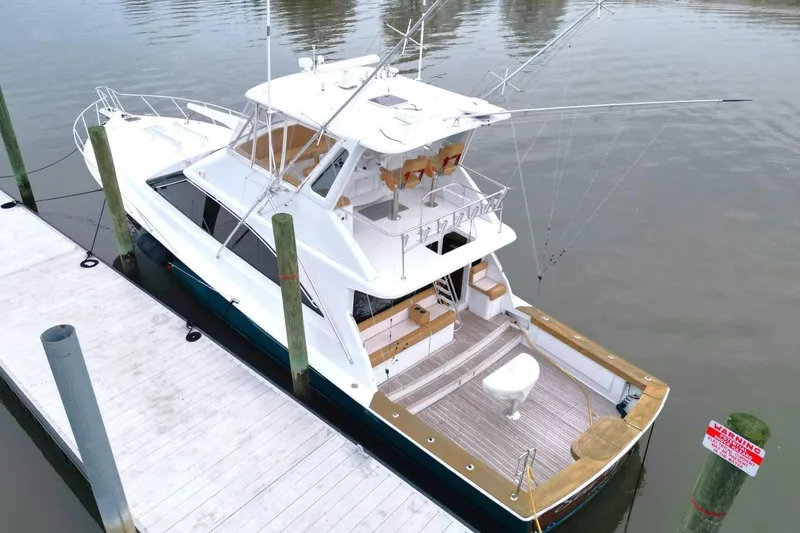 Slide: The Image of 1999 Ocean Yachts 60 Super Sport docked, aerial view showcasing spacious deck and fishing equipment. - 7