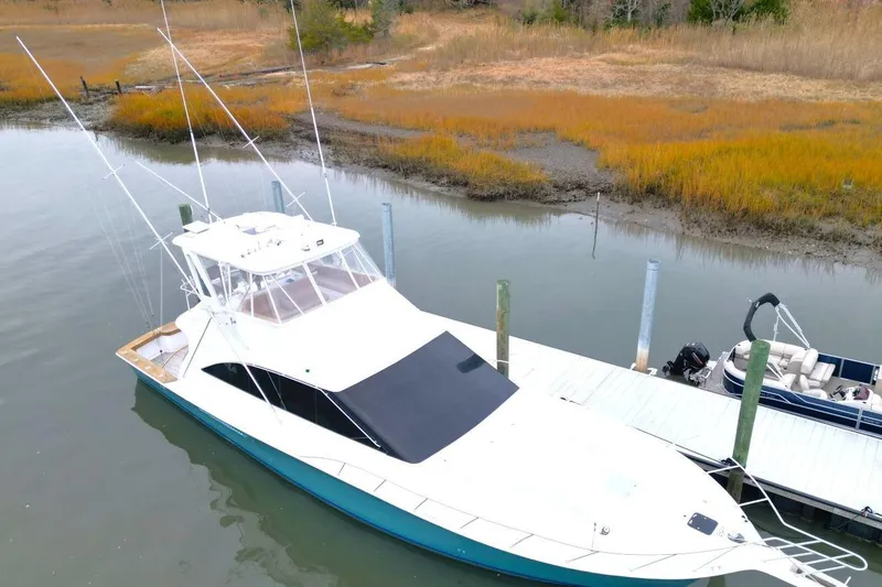 Slide: The Image of 1999 Ocean Yachts 60 Super Sport docked in a serene marina setting. - 9