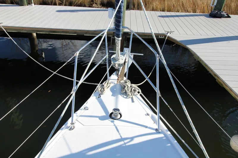 Slide: The Image of Bow of 2003 Catalina 320 sailboat docked, featuring ropes and railing. - 10