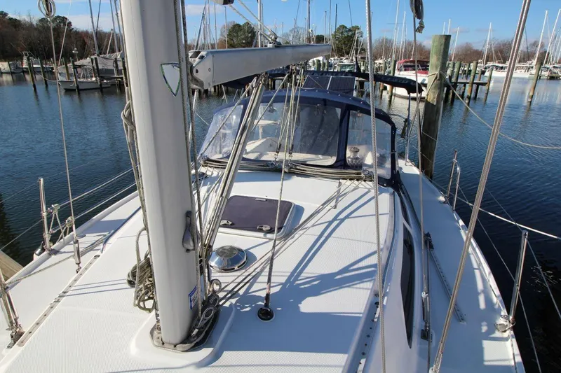 Slide: The Image of 2003 Catalina 320 sailboat docked in a marina, showcasing deck and rigging. - 11