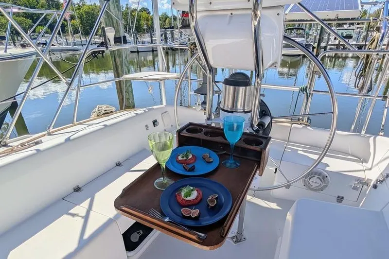 Slide: The Image of Cockpit of 2003 Catalina 320 sailboat with elegant dining setup and marina view. - 18