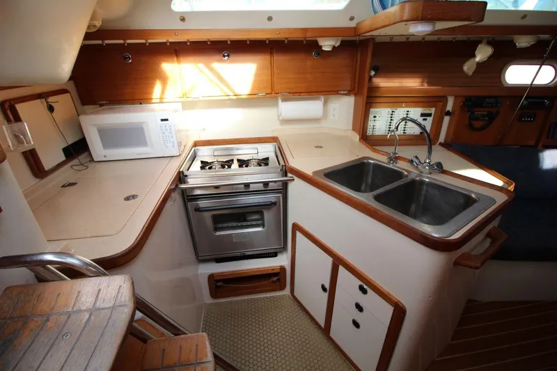 Slide: The Image of 2003 Catalina 320 yacht kitchen with stove, microwave, and double sink. - 21