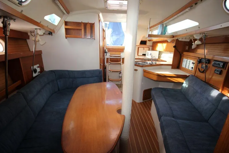 Slide: The Image of Interior of a 2003 Catalina 320 sailboat with cozy seating and wooden finishes. - 25