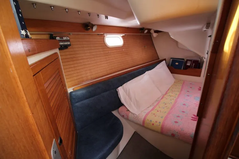 Slide: The Image of Cozy cabin interior of 2003 Catalina 320 sailboat with wood paneling and colorful bedding. - 26