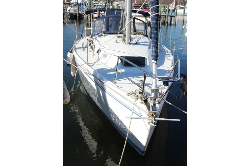 Slide: The Image of 2003 Catalina 320 sailboat docked in a marina, featuring a sleek white hull. - 6