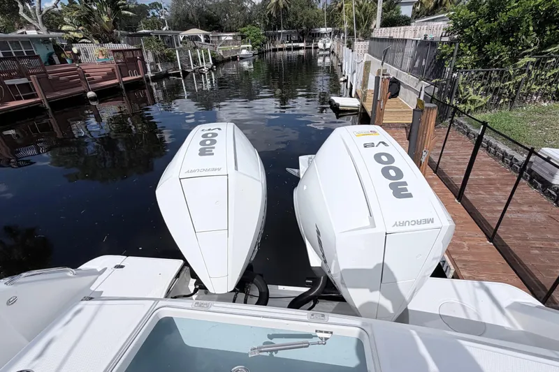 Slide: The Image of Boston Whaler 330 Outrage 2017 with twin Mercury 300 engines docked by a canal. - 15