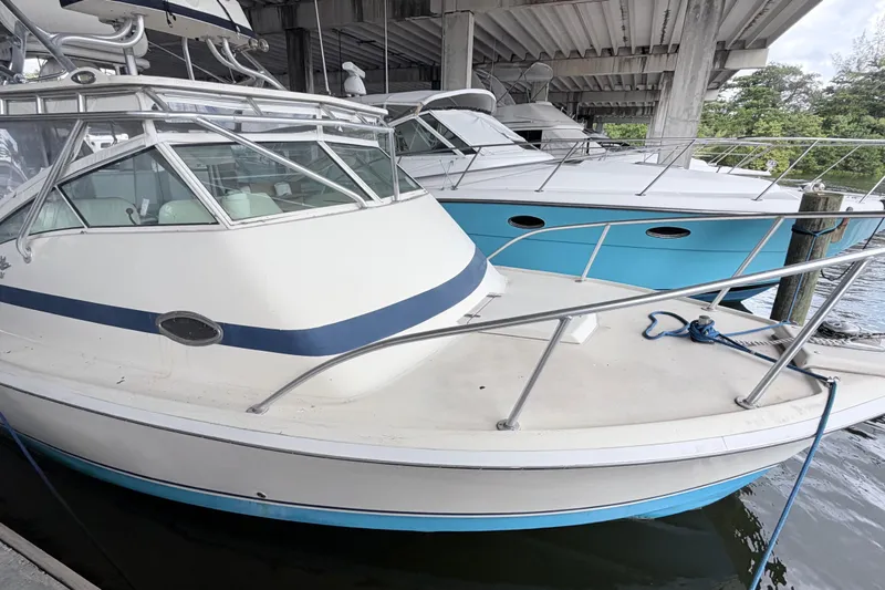 Slide: The Image of 1968 Bertram 31 Bahia Mar boat docked under a bridge, featuring a sleek design. - 16