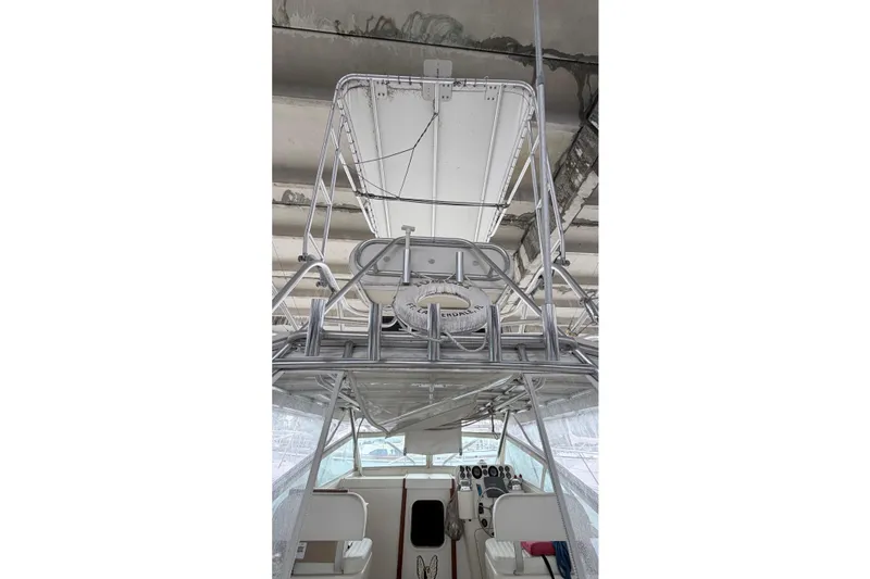 Slide: The Image of 1968 Bertram 31 Bahia Mar boat interior with helm and seating under a canopy. - 24