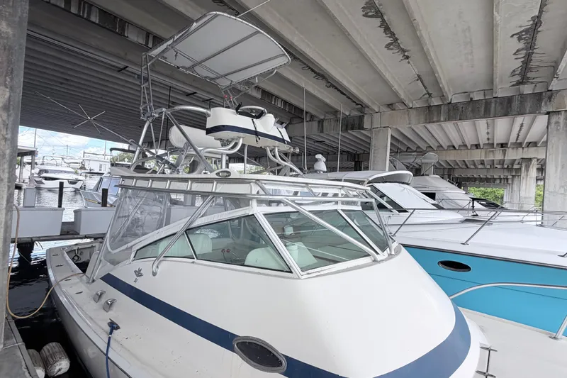 Slide: The Image of 1968 Bertram 31 Bahia Mar boat docked under a bridge, featuring a sleek design. - 3