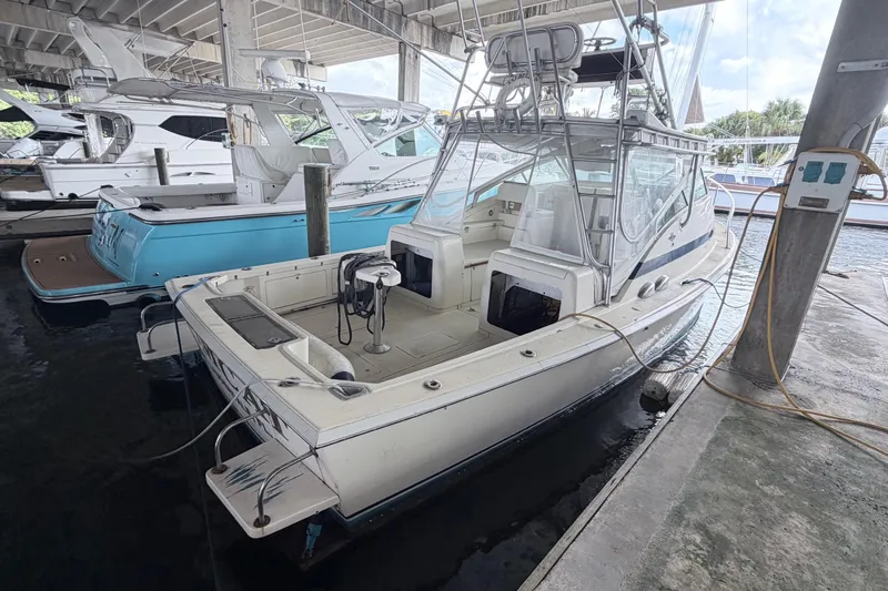 Slide: The Image of 1968 Bertram 31 Bahia Mar boat docked in a marina under a covered structure. - 6