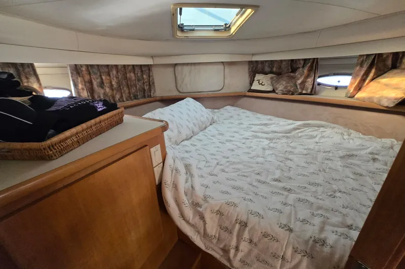 Slide: The Image of Cozy bedroom in 1995 Carver 430 Cockpit Motor Yacht with natural light and wood accents. - 13