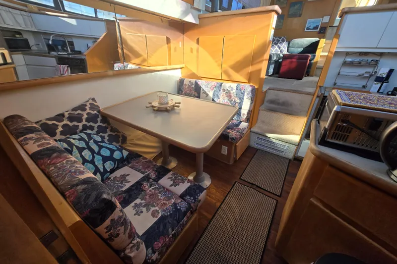 Slide: The Image of Interior of 1995 Carver 430 Cockpit Motor Yacht with cozy dining area and floral cushions. - 17