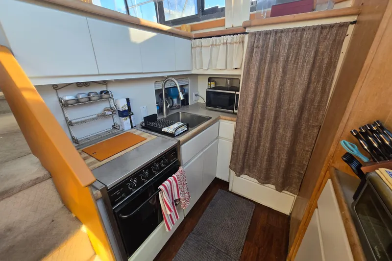 Slide: The Image of Compact kitchen in a 1995 Carver 430 Cockpit Motor Yacht, featuring modern appliances and storage. - 18