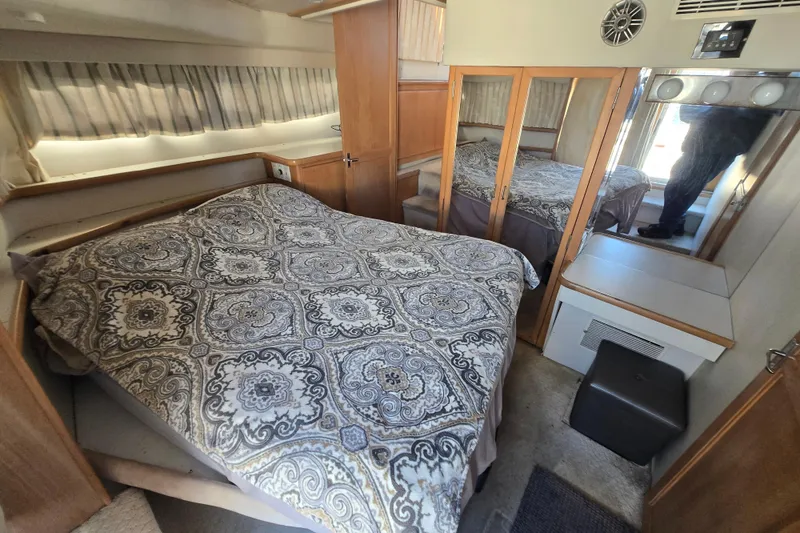 Slide: The Image of Interior of 1995 Carver 430 Cockpit Motor Yacht with cozy bedroom and patterned bedding. - 25