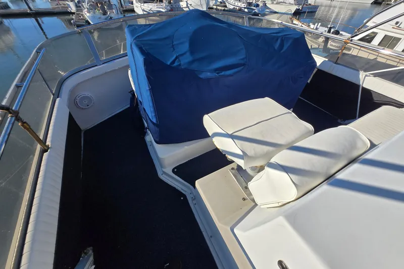 Slide: The Image of 1995 Carver 430 Cockpit Motor Yacht deck with covered seating and marina view. - 4