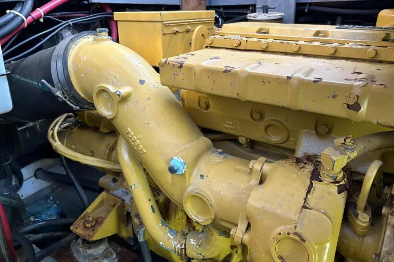 Slide: The Image of Engine of a 1999 Carver 430 Cockpit Motor Yacht, showing yellow components and piping. - 50