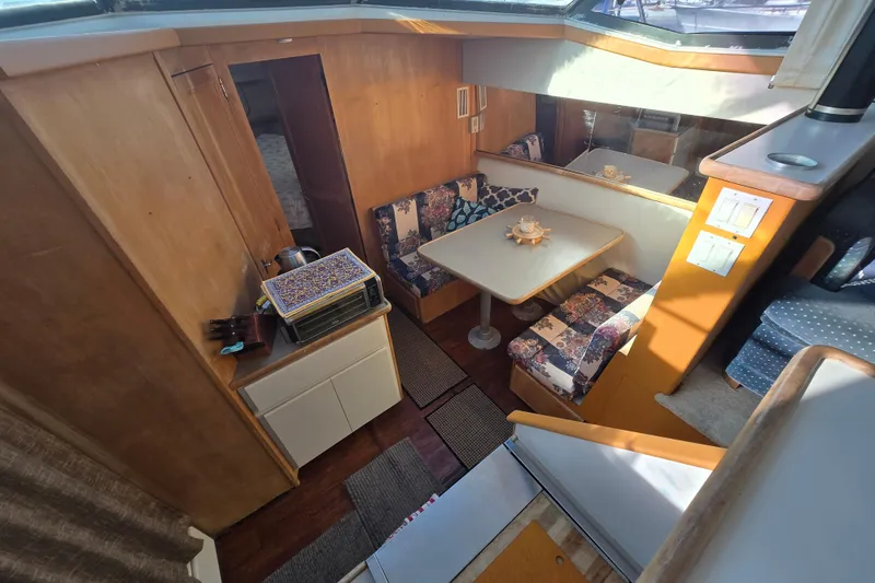 Slide: The Image of 1995 Carver 430 Cockpit Motor Yacht interior with dining area and kitchenette. - 12