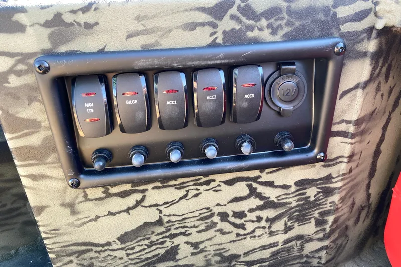 Slide: The Image of Control panel of 2026 Tracker Grizzly 1650 T Prairie Wings Edition with switches and 12V outlet. - 10