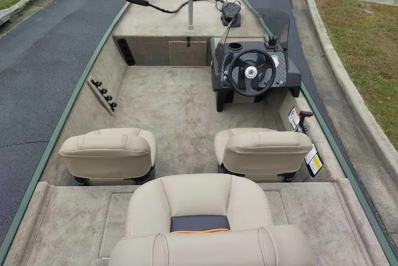 Slide: The Image of 2026 Tracker Bass Tracker Classic Limited boat interior with beige seats and steering console. - 3