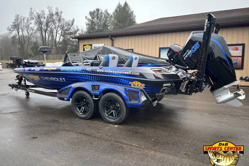 Slide: The Image of 2026 Ranger Z521 boat with custom graphics and powerful outboard motor, parked outside dealership. - 2